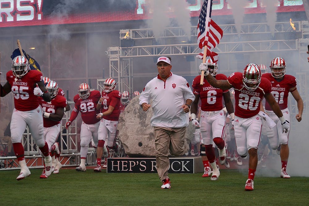 Coach Kevin Wilson and the IU football team run out onto the field prior to the homecoming game against Michigan State on Saturday at Memorial Stadium.