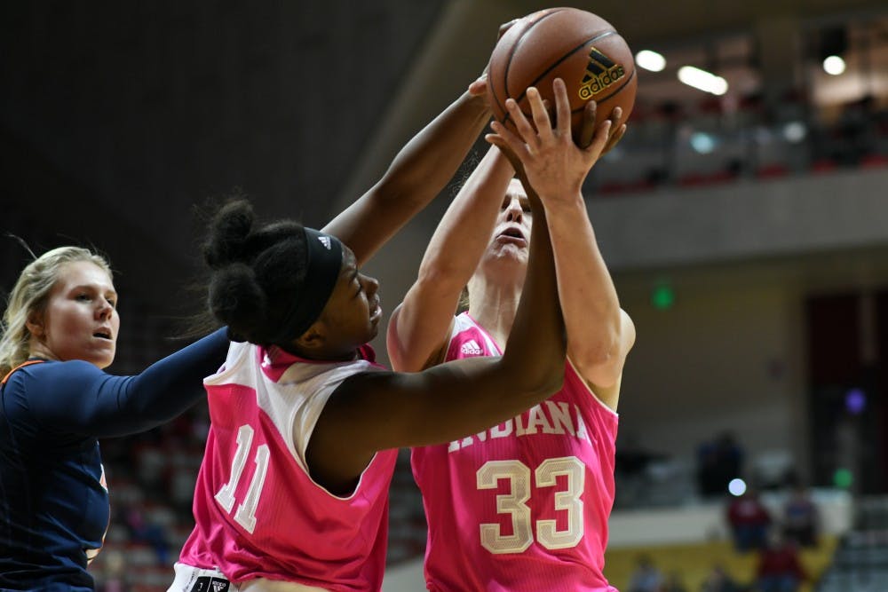 <p>Junior forward Kym Royster, left, and senior forward Amanda Cahill grab a rebound against Illinois February 8 in Simon Skjodt Assembly Hall. Cahill and Royster combined for 39 points in IU's 70-54 win against Illinois.</p>