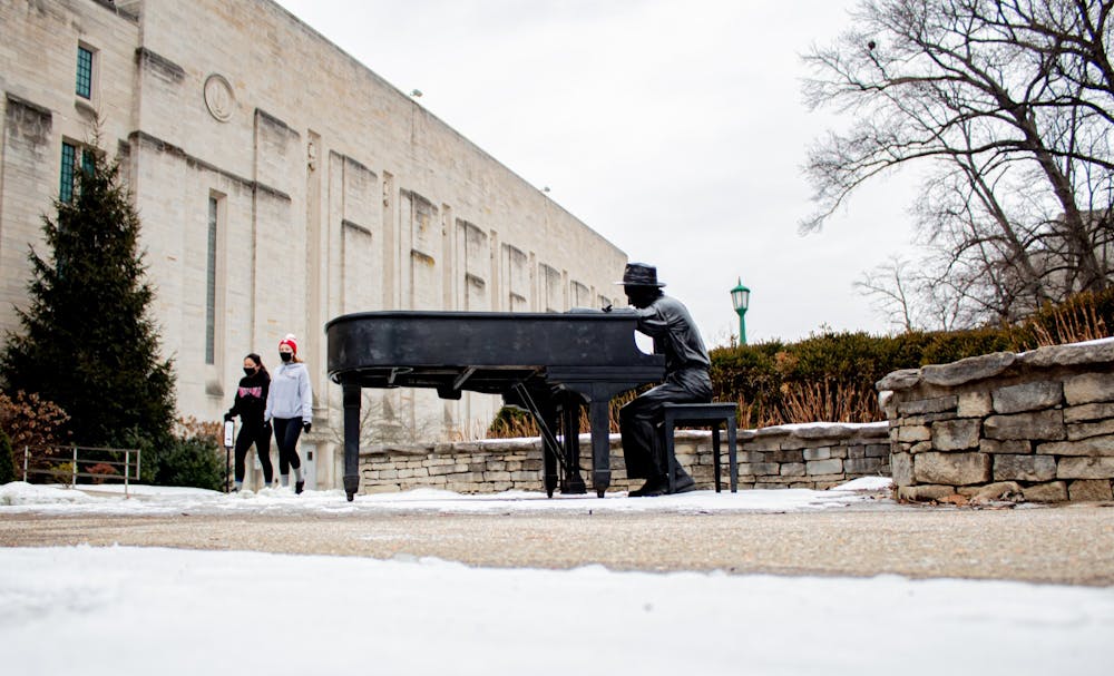 <p>Students walk Monday by the Hoagy Carmichael sculpture outside of the IU Auditorium. Temperatures are expected to reach a low of -4 degrees in Bloomington this week.  </p>