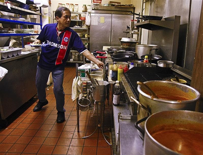 Siam House employee Naphat Lek cooks in the kitchen Nov. 8 at Siam House.