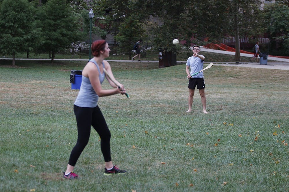 Senior Ariel Kepler hits the ball to her teammate, Ian Hutchinson, during a hurling practice Monday at Dunn Meadow. The two are a part of IU's Hurling team, who play the Irish sport for fun in their free time. 