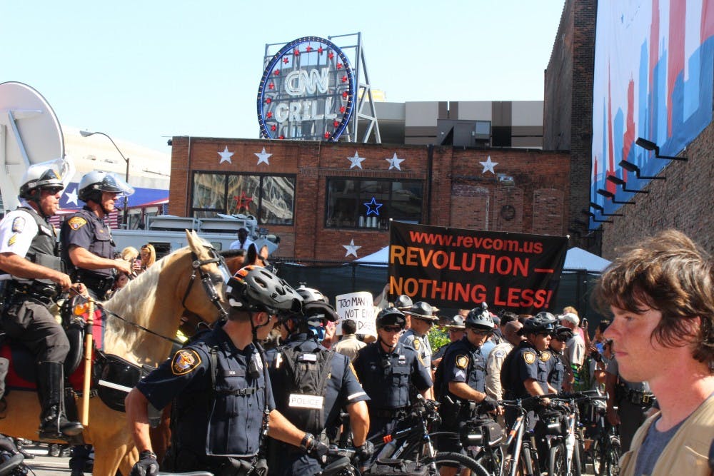 Police officers on horses order crowds to disperse after an American flag burning demonstration sparked controversy on Fourth and Prospect during the third day of the Republican National Convention.