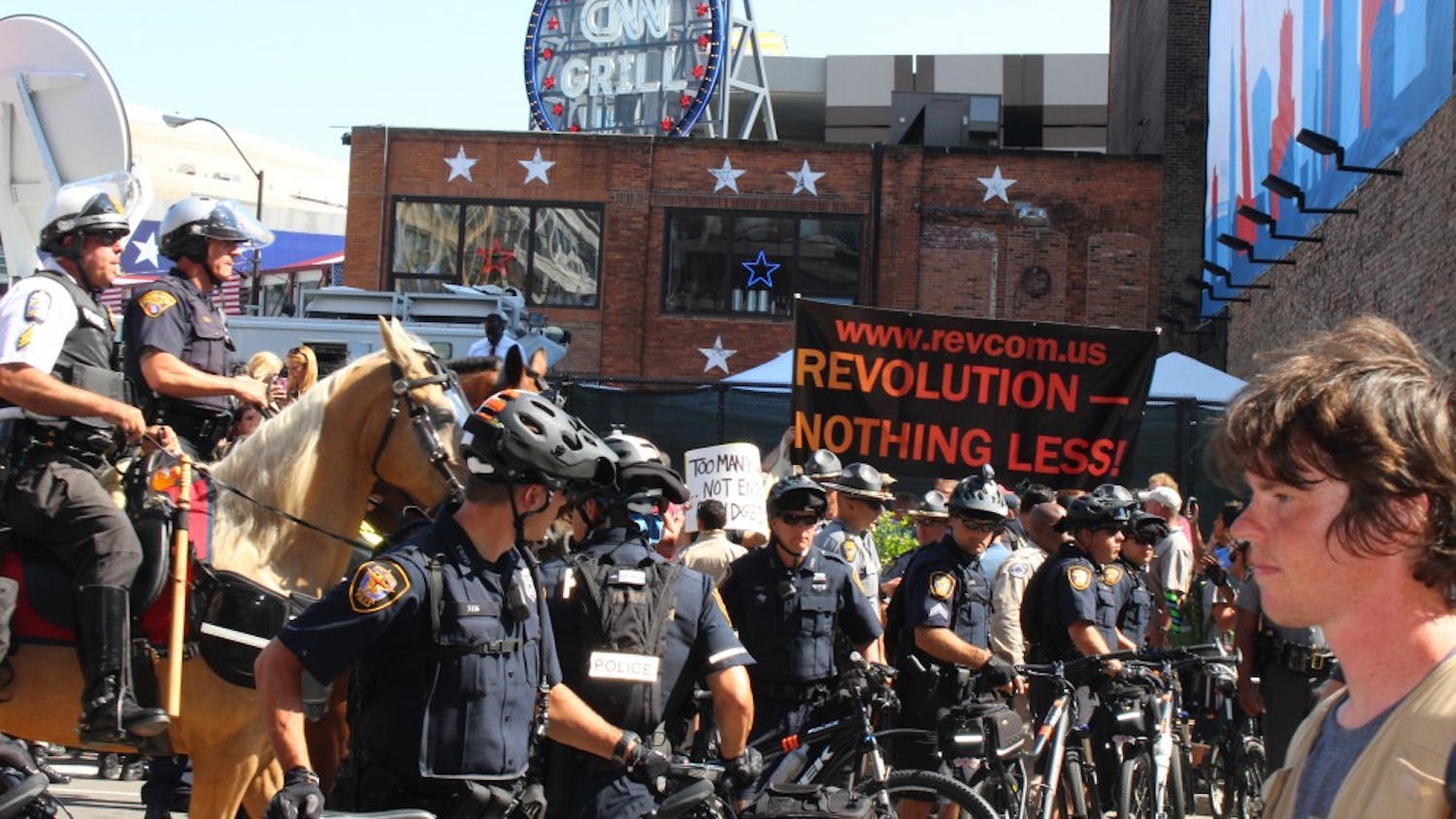 Police officers on horses order crowds to disperse after an American flag burning demonstration sparked controversy on Fourth and Prospect during the third day of the Republican National Convention.