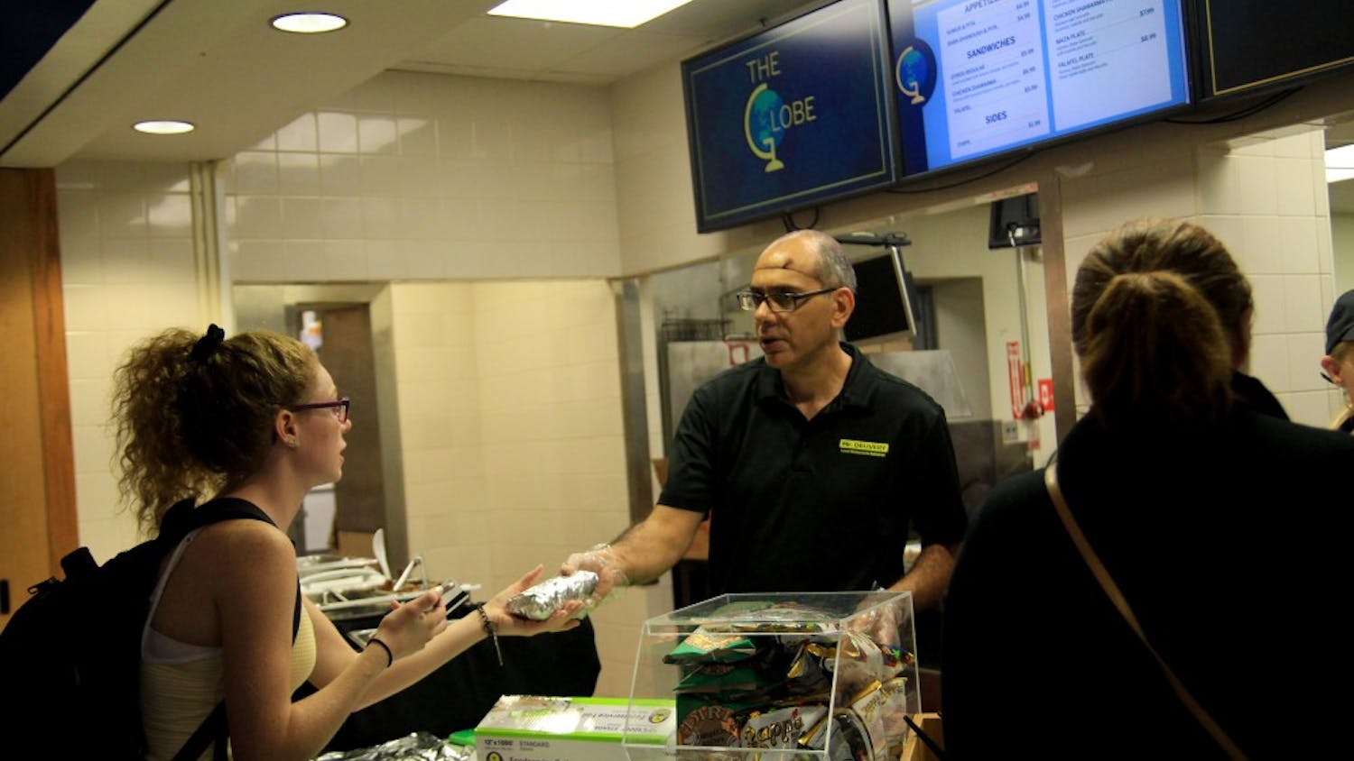 A worker hands food from Btown Gyros to a student at the Globe in the Indiana Memorial Union. Starting this week, the Globe in the IMU serves food from different restaurants around Bloomington.&nbsp;