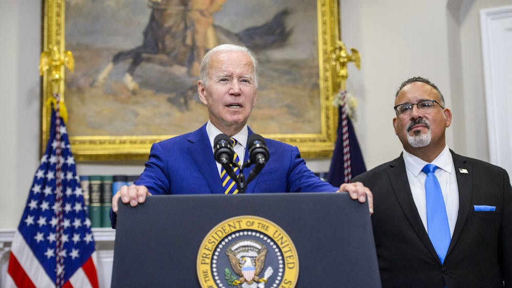 President Joe Biden speaks as Secretary of Education Miguel Cardona looks on after Biden announced a federal student loan relief plan Aug. 24, 2022, in the Roosevelt Room at the White House. The student loan debt forgiveness application opened Oct. 14.