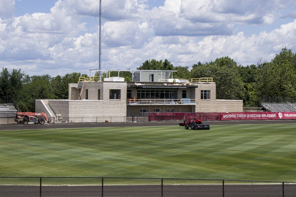 A groundskeeper mows the lawn June 25 as construction workers renovate Bill Armstrong Stadium. The stadium is home to the annual Little 500 race and IU's men’s and women’s soccer teams.