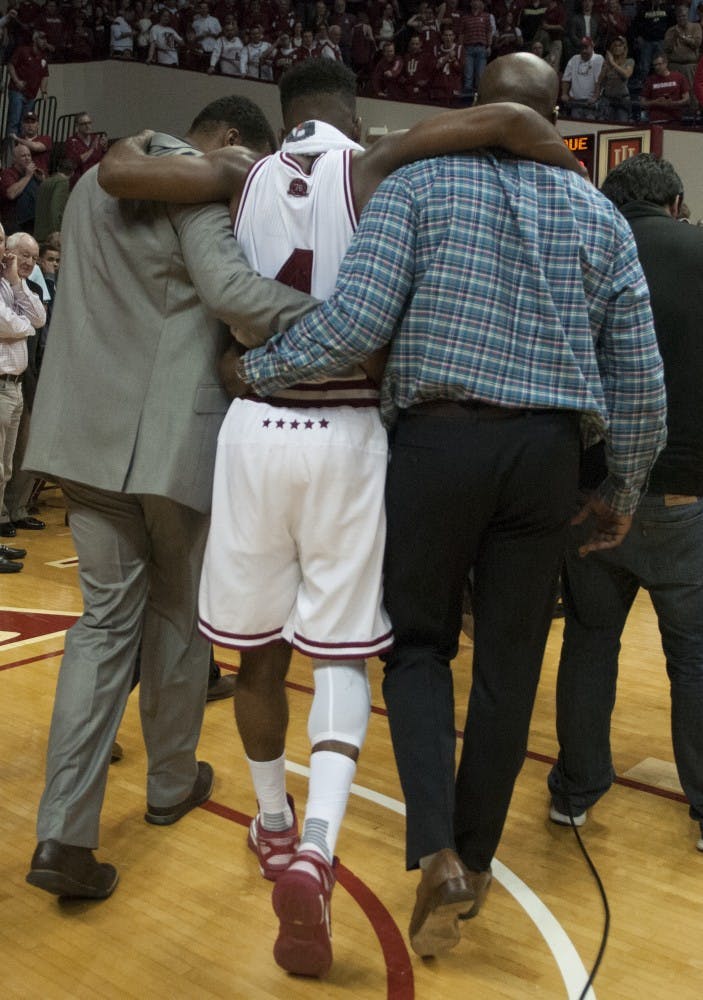 Sophomore guard Robert Johnson is helped off the court after the game against Purdue on Saturday at Assembly Hall. The Hoosiers won 77-73.