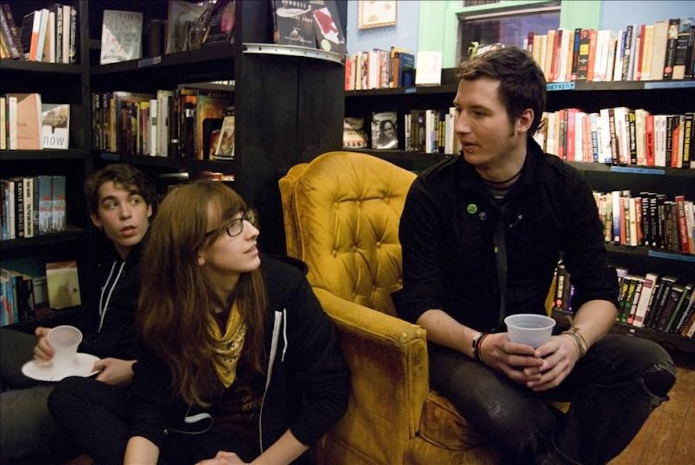 Bloomington High School North senior Dylan Galyan-Wilkerson looks on as Harmony High School senior Izzy Jarvis talks to coordinator Steven Stothard at Boxcar Books Saturday evening. Boxcar Books celebrated its seventh anniversary Saturday with a two-hour open house and a raffle.