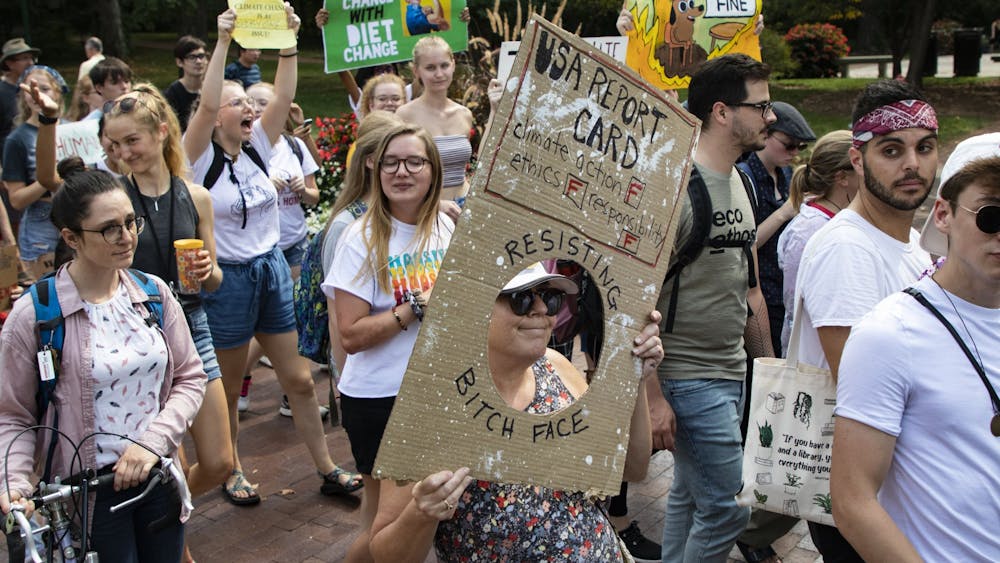 Protestors walk with signs during the Bloomington Climate Strike rally Sept. 20, 2019, in front of Franklin Hall. President Joe Biden&#x27;s climate plan includes reaching net-zero emissions by 2050.