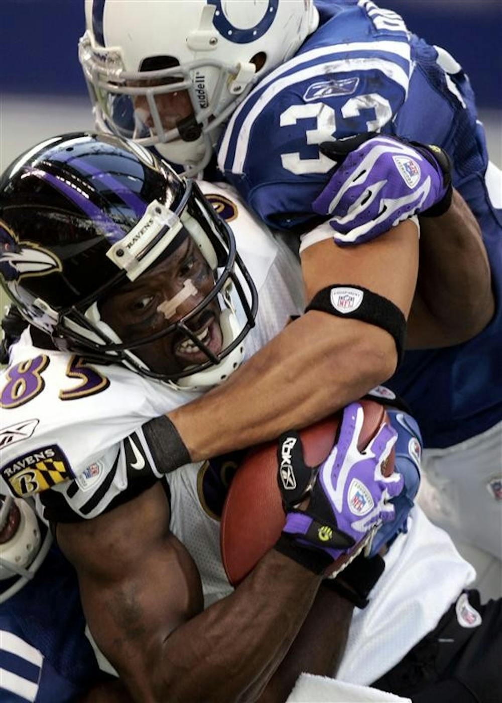 Baltimore Ravens wide receiver Derrick Mason (85) is tackled after a reception, by Indianapolis Colts' Melvin Bullitt (33) during the second half of an NFL football game on Sunday in Indianapolis. The Colts won 31-3, marking the team's first regular-season victory at Lucas Oil Stadium.