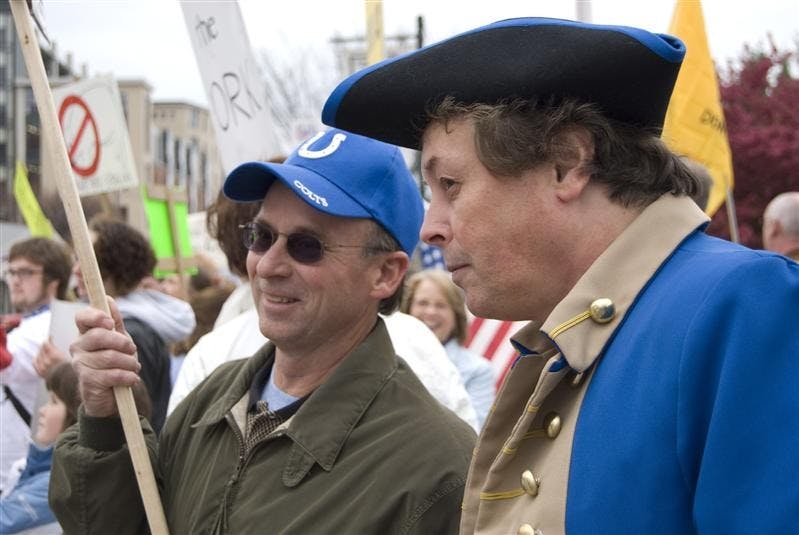 Bloomington resident Mark Walcott talks with fellow resident Randy Carmichael, who is dressed as a revolutionary officer, during a "tea party" protest outside City Hall on Wednesday evening. When asked why he was dressed as a revolutionary, Carmichael responded, "If something's not done, [revolution] is what we're gonna wind up back at. If we all voted Libertarian, we wouldn't be here today."