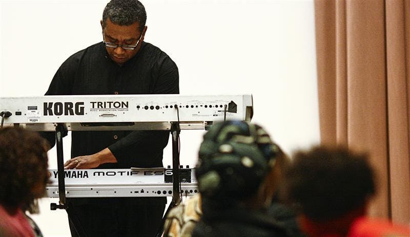 Top right: Keith McCutchen, director of the African American Choral Ensemble, plays the keyboard during the ceremony. 