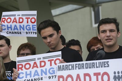 Prakland shooting survivors David Hogg and Cameron Kaskey (left to right) hold signs during a press conference June 4, 2018, for the March for Our Lives movement in Parkland, Florida. 