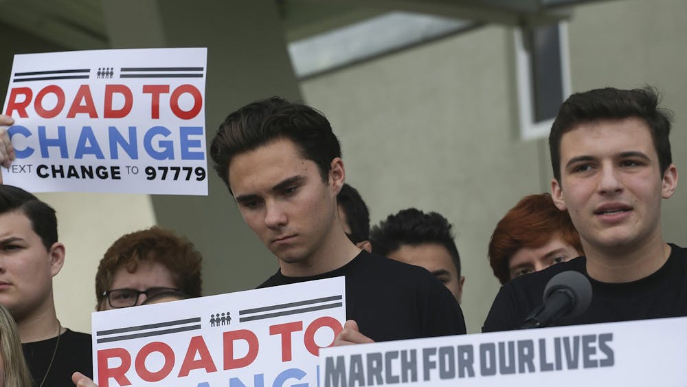 Parkland shooting survivors David Hogg and Cameron Kaskey (left to right) hold signs during a press conference June 4, 2018, for the March for Our Lives movement in Parkland, Florida. 