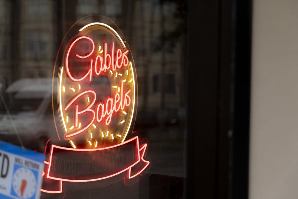 <p>A Gables Bagels neon sign is seen through the door of the restaurant Sept. 5, 2022, on East Third Street. The store is owned by Ed Schwartzman, who also owns BuffaLouie’s in Bloomington.</p>