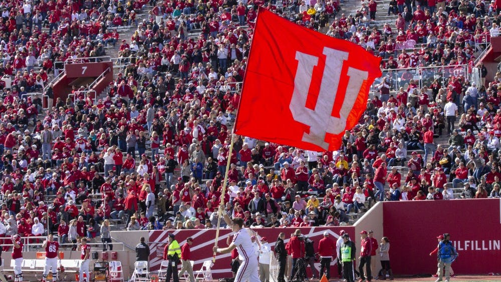 Gavin Schmuckler runs the IU flag across the field Oct. 13, 2018, at Memorial Stadium. IU swim and dive signee Emily Weiss became the 11th swimmer in Indiana history to ever win four state championships Feb. 9.&nbsp;
