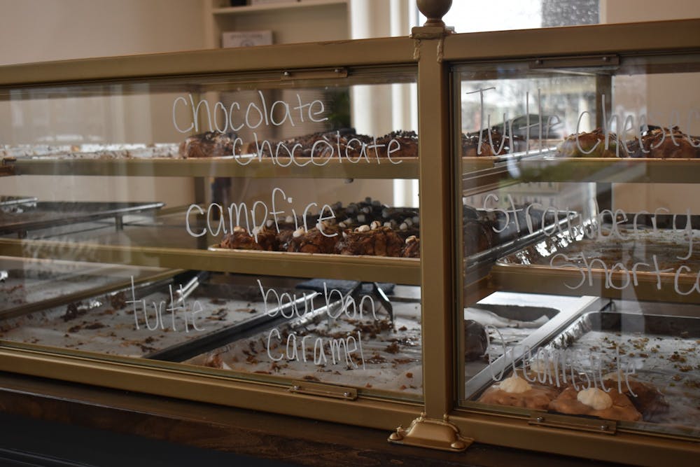 <p>A display case is shown with a variety of donuts in Parlor Donuts on Sept. 13. The shop is located in the former Laughing Planet location on East Kirkwood Street.</p>