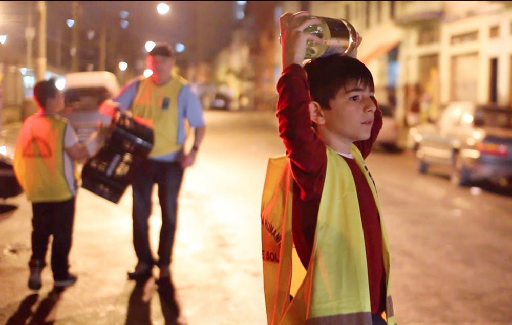 A young volunteer hands out free water to residents of Cracolândia Saturday evening. The volunteer group Instituto Construir, or Construction Institute, makes bulk amounts of soup every Saturday night and distributes it to the homeless living in the center of São Paulo.