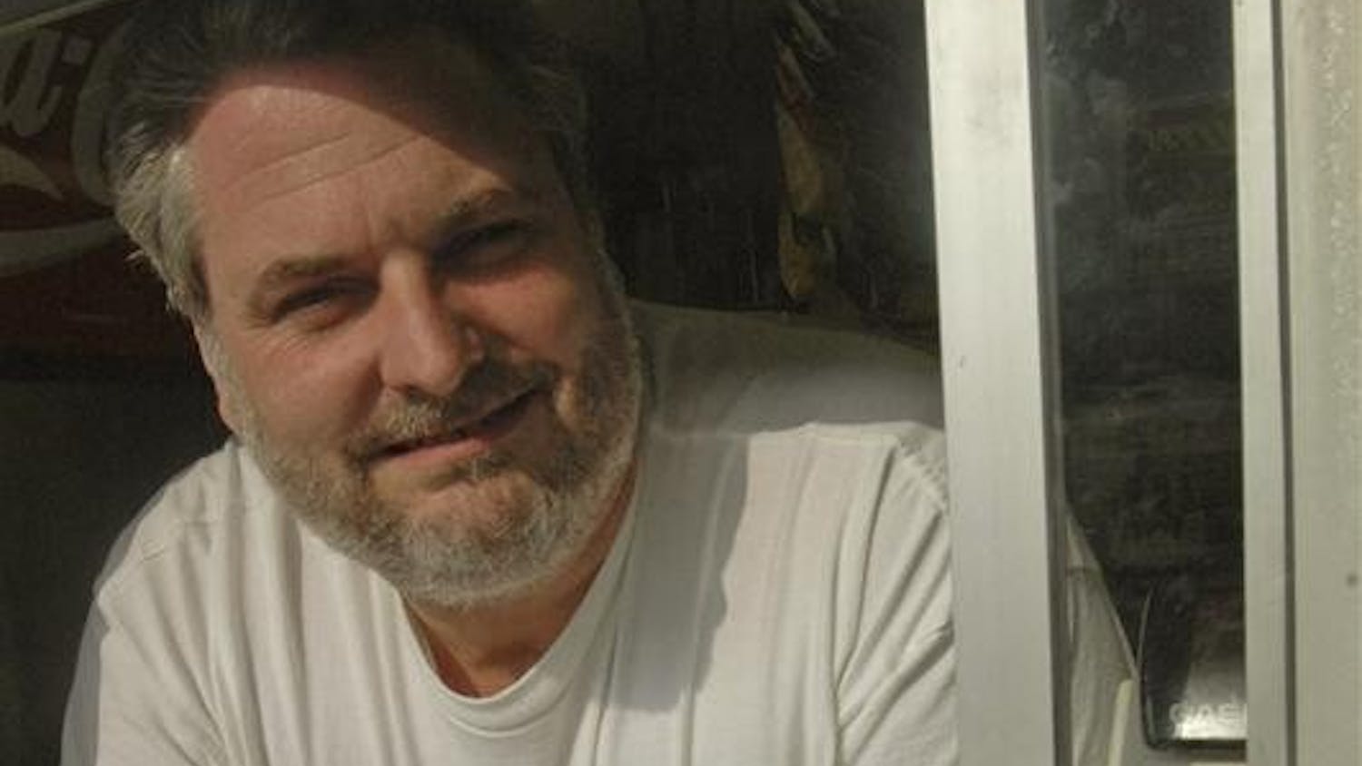 Chocolate Moose owner Tim May stands next to a soft-serve creation in his shop at 401 S. Walnut St.