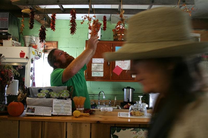 Musgrave Orchard and Cider Mill co-owner and IU alumnus Andy Hamilton handles some of his store products on Sunday.