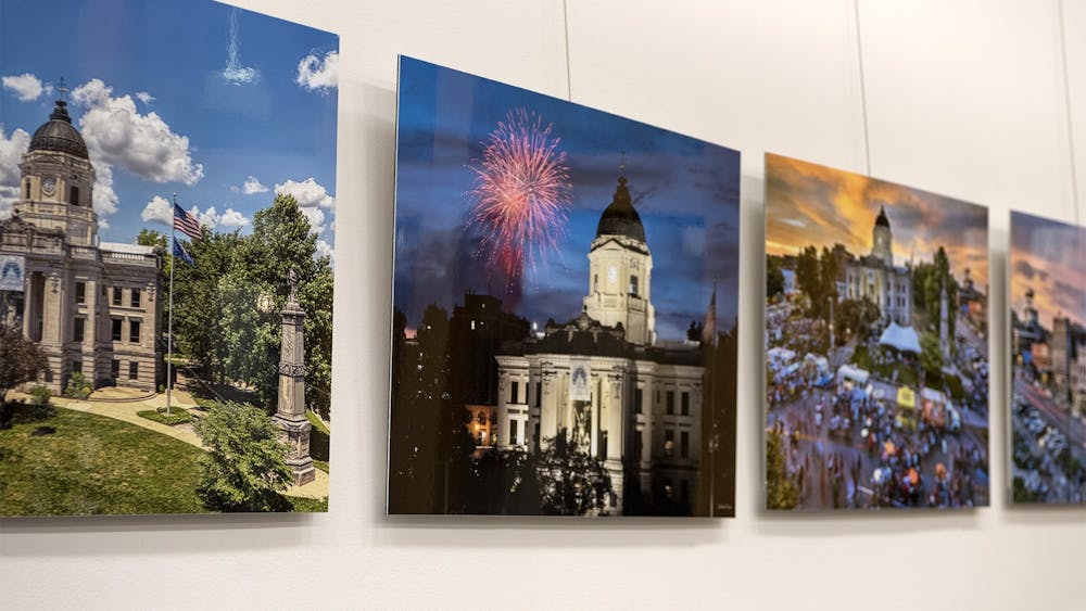 过去的画廊走在墙上的照片展示在墙上。7月9日的7月布卢明顿画廊散步展示了九个画廊的各种当地艺术品。