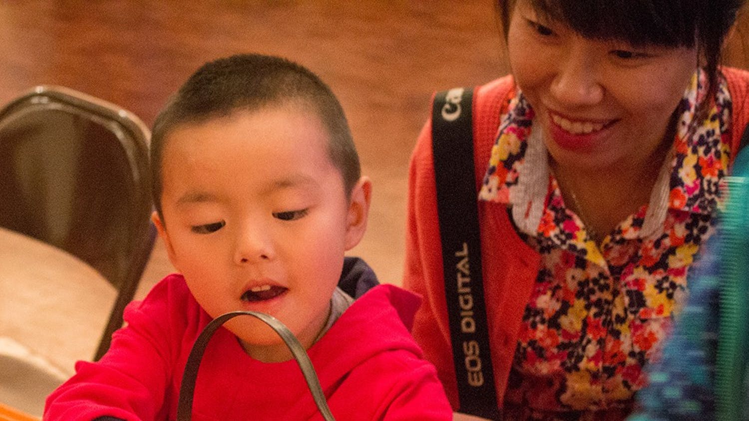 Yoyo Xu picks out candy with his mother Luming after making a monster bookmark at the Mathers Museum's Halloween Family Fun Fest.