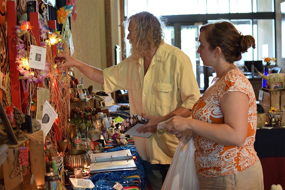 Curators Rachel DiGregorio and Michael Redman add the final decorations to the 10th annual installation of the community altar. Redman said the altar expands each year to add the offerings collected from previous years.