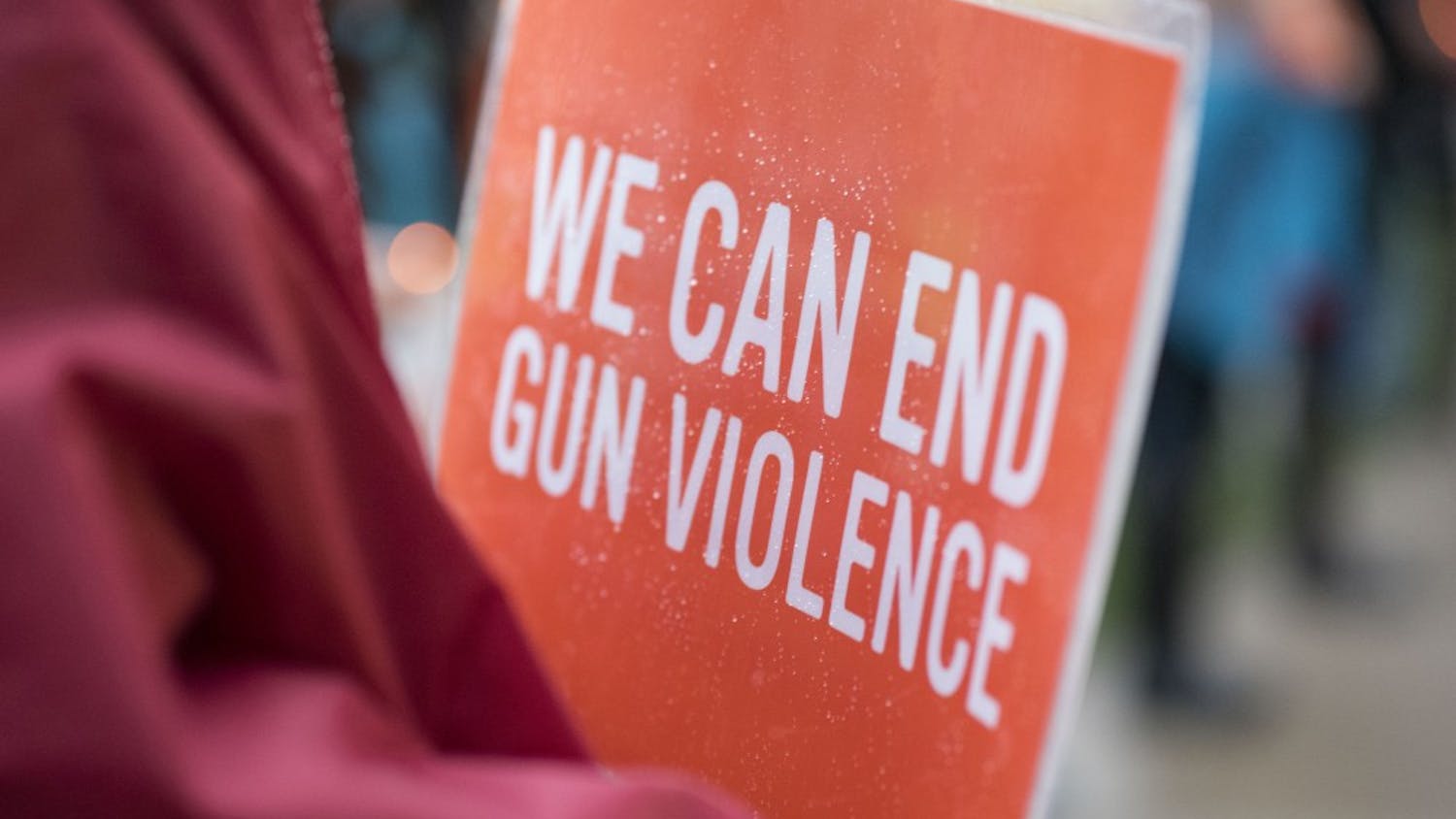 Ann Edmonds holds a sign at the Sunday vigil honoring victims of the Las Vegas shooting. The signs were distributed by Moms Demand Action, a group advocating stricter gun laws.