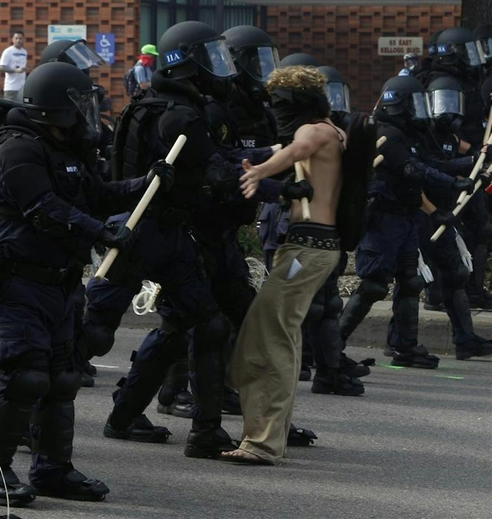 A protester stands against the police line during their protest Tuesday at the Republican National Convention. Although the protester stood still, once the police came upon him, he was knocked over and then arrested.