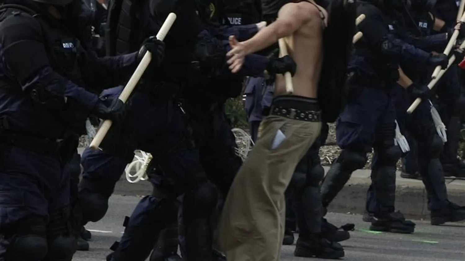 A protester stands against the police line during their protest Tuesday at the Republican National Convention. Although the protester stood still, once the police came upon him, he was knocked over and then arrested.