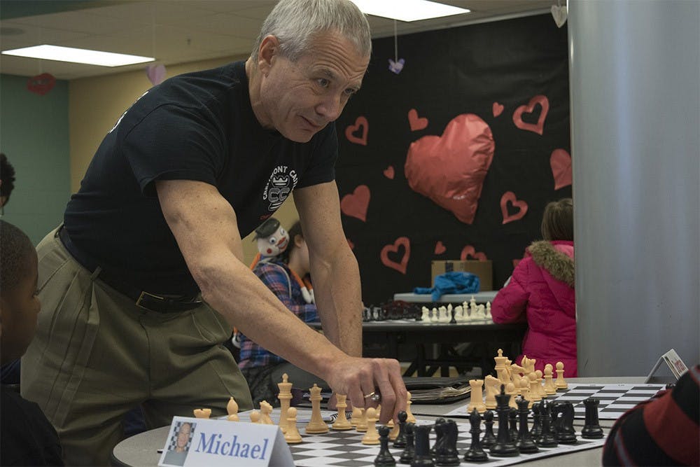 Michael May teaches children how to play chess at Fairview Elementary School Tuesday afternoon. May goes to the school every week to help teach kids how to play chess.