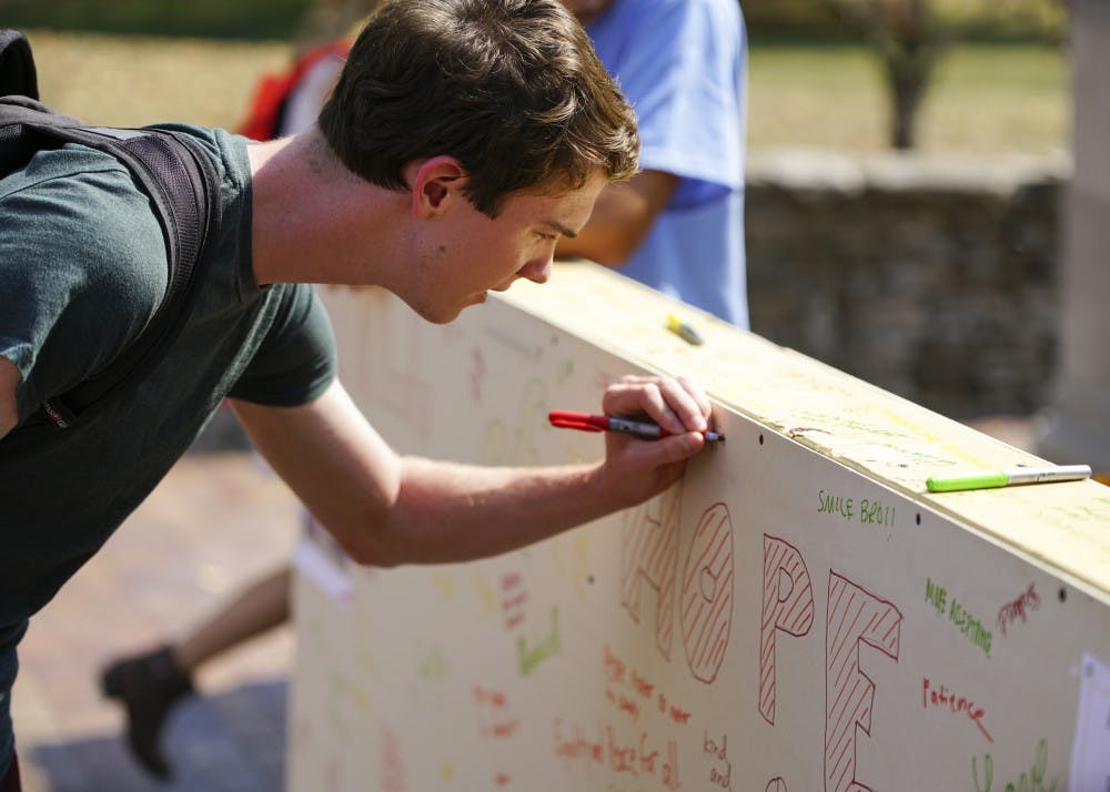Freshman Nick Broderick signs the Wall of Prejudice during Pi Lambda Phi’s Elimination of Prejudice Week event Wednesday afternoon in front of the gates of the Arboretum on Tenth Street and Fee Lane. The event is a part of Pilam’s Week of Philanthropy and aims to bring hope and draw attention to prejudice on campus.