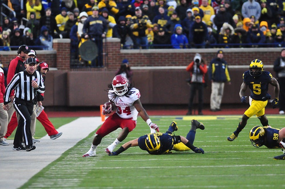 Junior running back Devine Redding dodges Michigan defenders at Michigan Stadium on Saturday. IU lost 20-10.