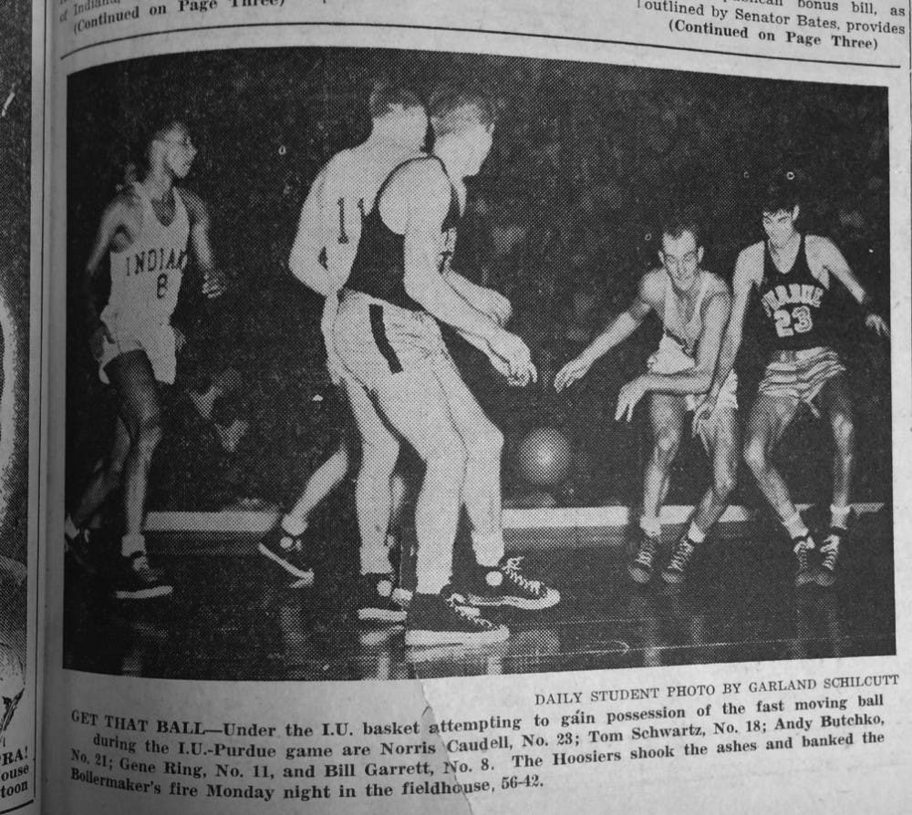 GET THAT BALL -- Under the IU basket attempting to gain possession of the fast moving ball during the IU-Purdue game are Norris Caudell, No. 23; Tom Schwartz, No. 18; Andy Butchko, No. 21; Gene Ring, No. 11, and Bill Garrett, No. 8. The Hoosiers shook the ashes and banked the Boilermaker's fire Monday night in the fieldhouse, 56-42. Photo by Garland Schilcutt / IDS