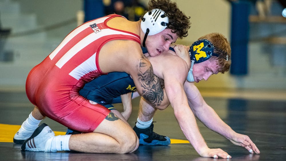 Sophomore Aca Garcia grapples on Sunday in Ann Arbor, Michigan, with Michigan wrestler Jack Medley. Garcia won 11-6 in the 133-pound weight class against Medley, a member of the No. 3 ranked Michigan Wolverines.