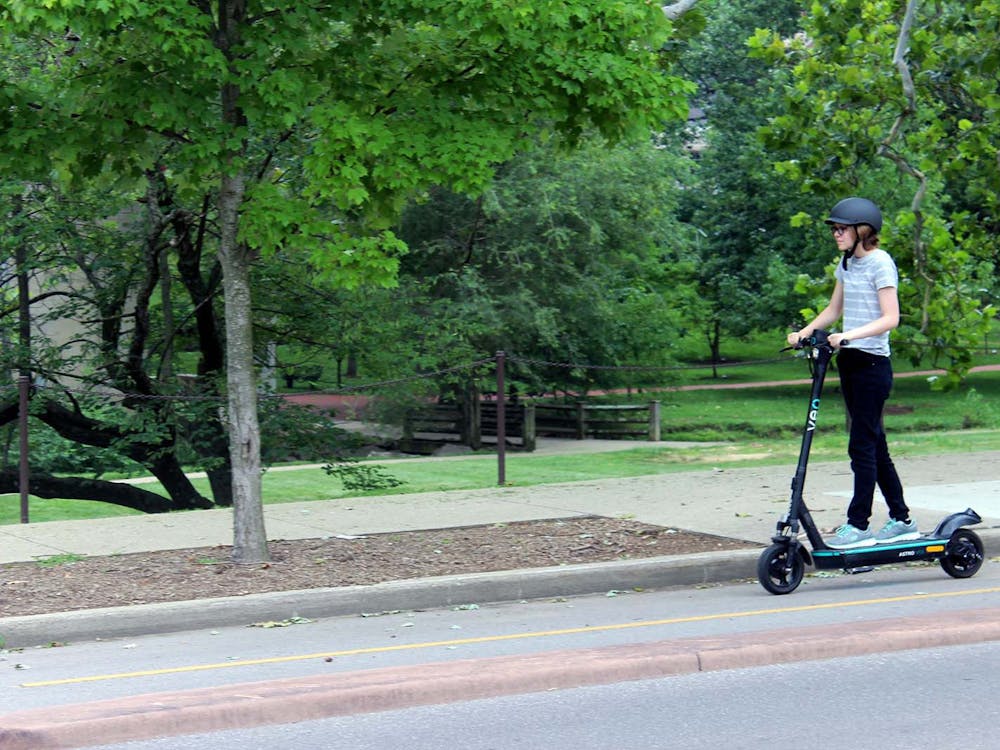 A student rides an e-scooter in a bike lane near the IU campus. 