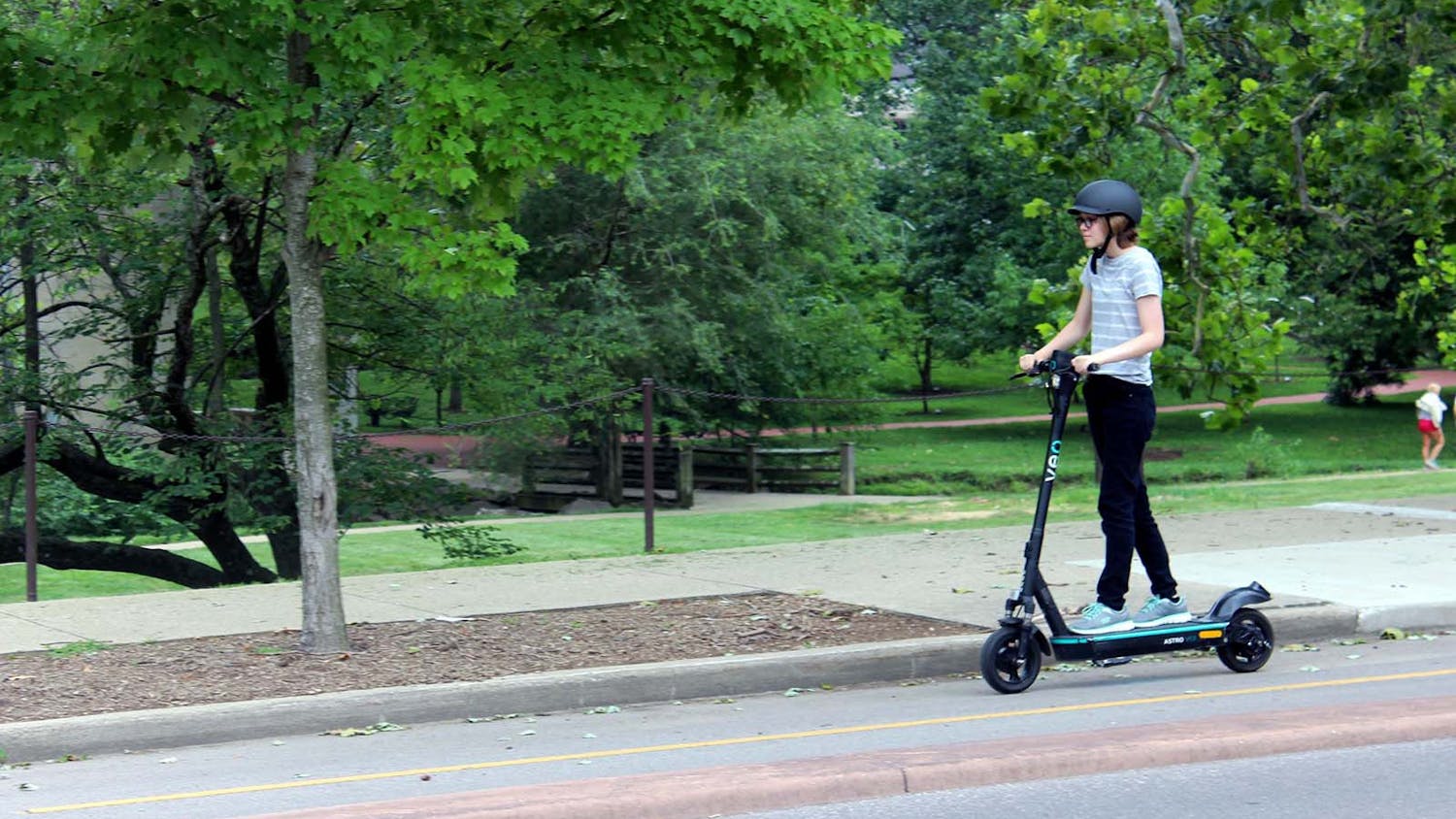 A student rides an e-scooter in a bike lane near the IU campus. 