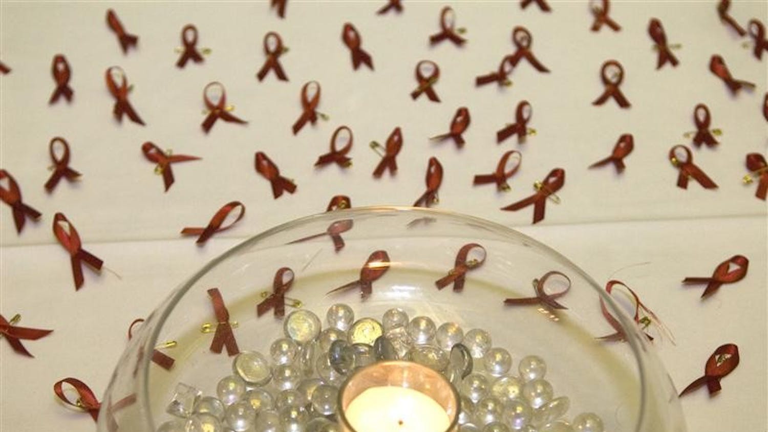 Red ribbons signifying AIDS awareness sit on a table Monday outside the Ballroom at Fountain Square Mall. The ribbons were available for those attending an event recognizing World AIDS Day.