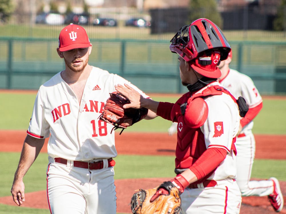 Redshirt senior catcher Collin Hopkins high fives senior pitcher Braden Scott during a game against Purdue on Saturday at Bart Kaufman Field. The Hoosiers won two of three games against the Purdue Boilermakers this weekend.
