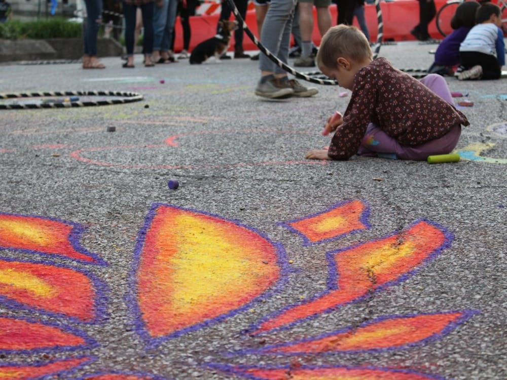 Children play with chalk during the 2018 Lotus World Music &amp; Arts Festival on Sept. 28.