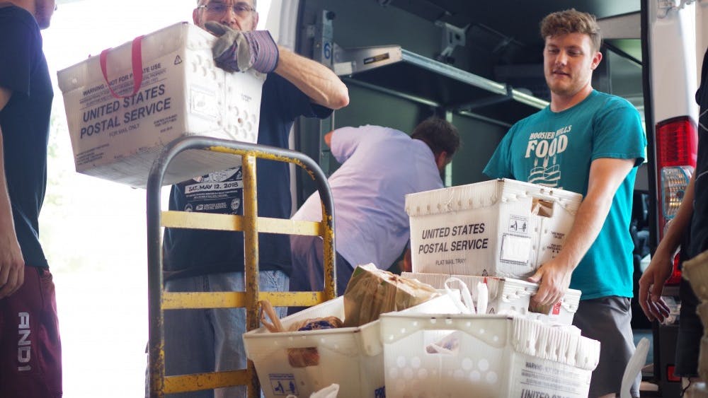 Dan Morelli, left, and Brandon Bartley, right, unload a U.S. Postal Service van during the Stamp Out Hunger food drive May 12.