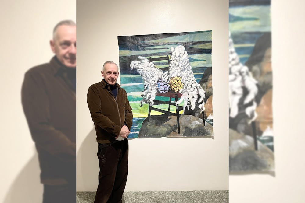 <p>Italian artist Andrea Ventura poses by one of his paintings in his Vanitas exhibition at the Grunwald Gallery Jan. 12, 2022. Ventura said the painting was inspired by his relationship with his identical twin brother.</p>