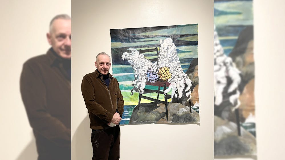 Italian artist Andrea Ventura poses by one of his paintings in his Vanitas exhibition at the Grunwald Gallery Jan. 12, 2022. Ventura said the painting was inspired by his relationship with his identical twin brother.