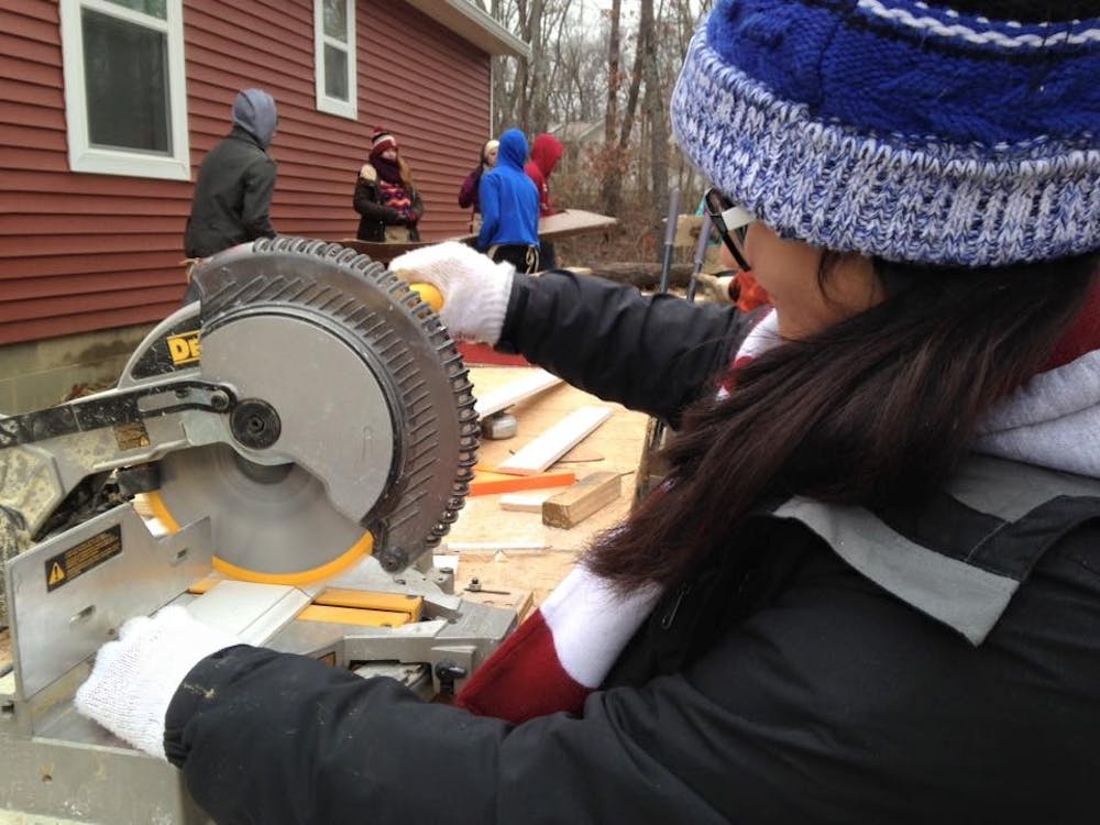 An IU student saws lumbers on Jan. 16 at Habitat for Humanity build site. The group will be co-sponsoring a house for the first time in almost two decades.  