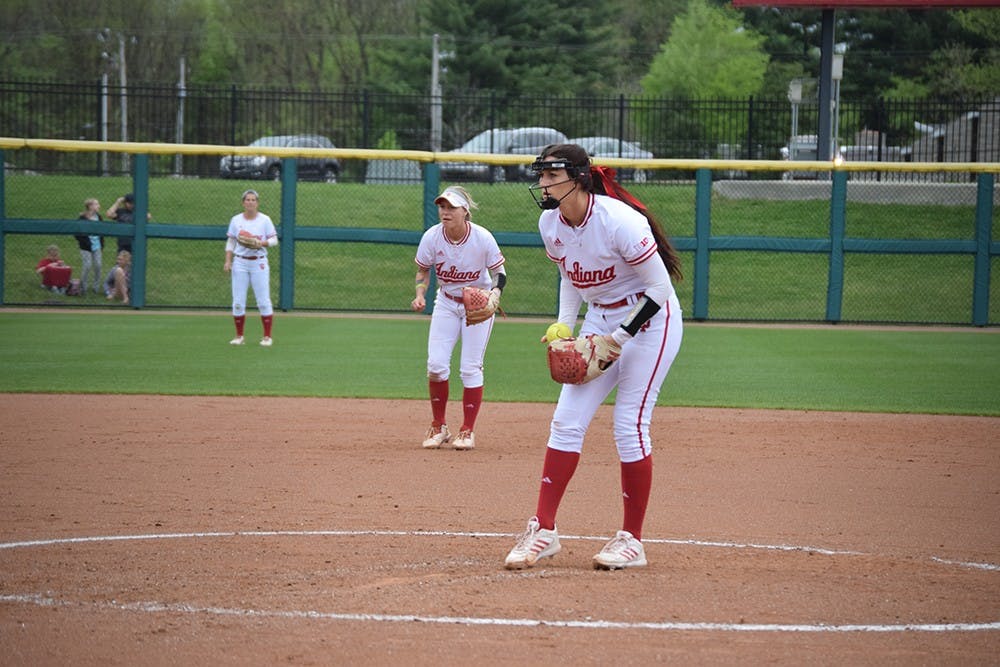 Sophomore pitcher Emily Kirk focuses on the strike zone while shortstop Rachel O'Malley prepares for a play in the background on Friday, April 21, 2017. The Hoosiers defeated the Terrapins in all three games in Bloomington.