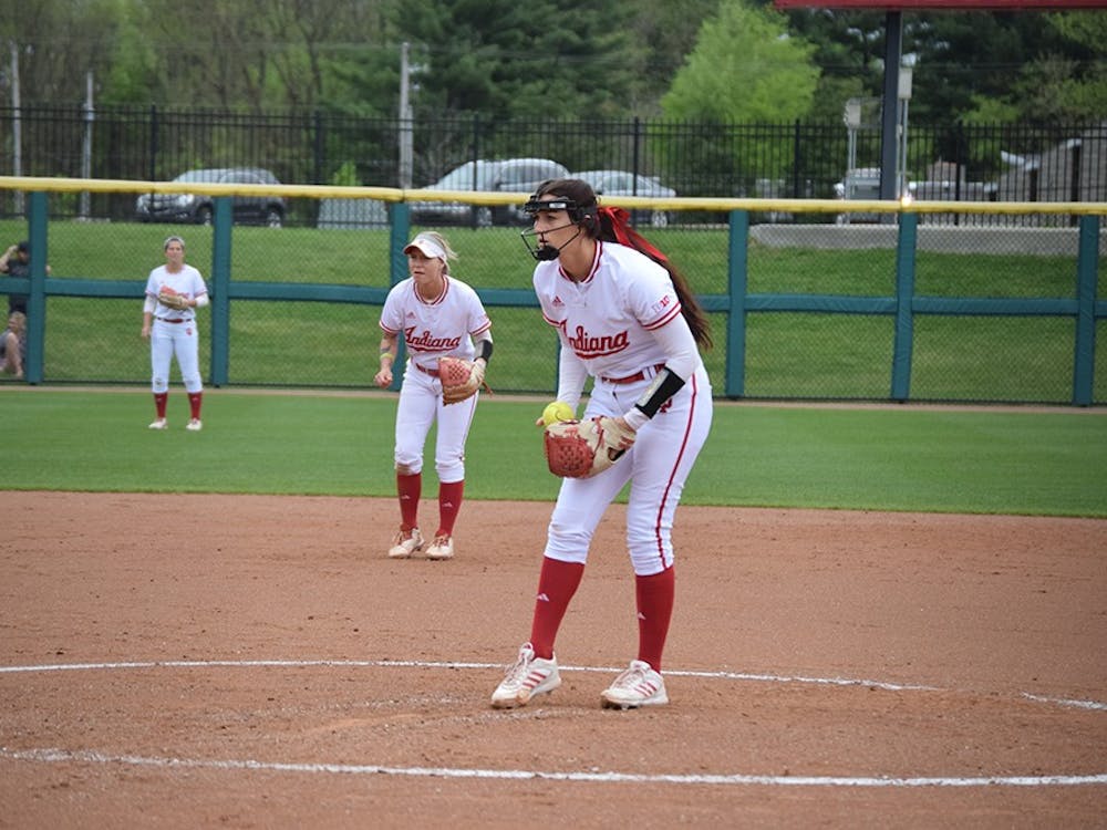 Sophomore pitcher Emily Kirk focuses on the strike zone while shortstop Rachel O'Malley prepares for a play in the background on Friday, April 21, 2017. The Hoosiers defeated the Terrapins in all three games in Bloomington.