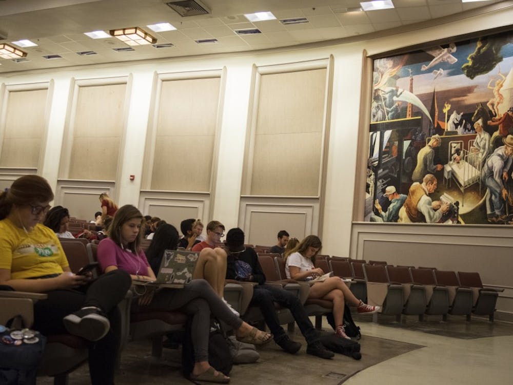 在伍德伯恩100，学生们等待上课。讲堂里有一幅由托马斯·哈特·本顿在1933年创作的壁画，这幅壁画因在背景中描绘了蒙面的三k党成员而引起争议。