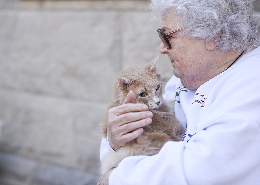 Nan Miller holds her cat Snickers before the pet blessing on Saturday. The Trinity Episcopal Church held a pet blessing in celebration of Saint Francis' feast day.