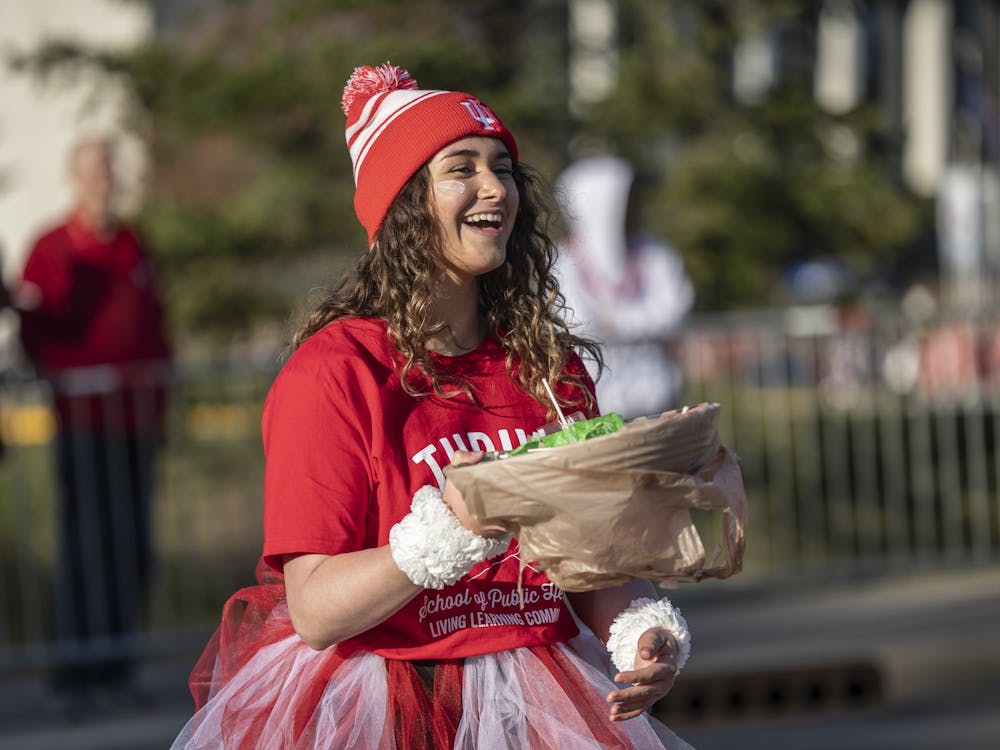 A representative of the School of Public Health Living Learning Community smiles at Hoosier fans during the IU Homecoming Parade on Oct. 7, 2022, on 17th Street. Both student and community groups were able to walk in the parade.