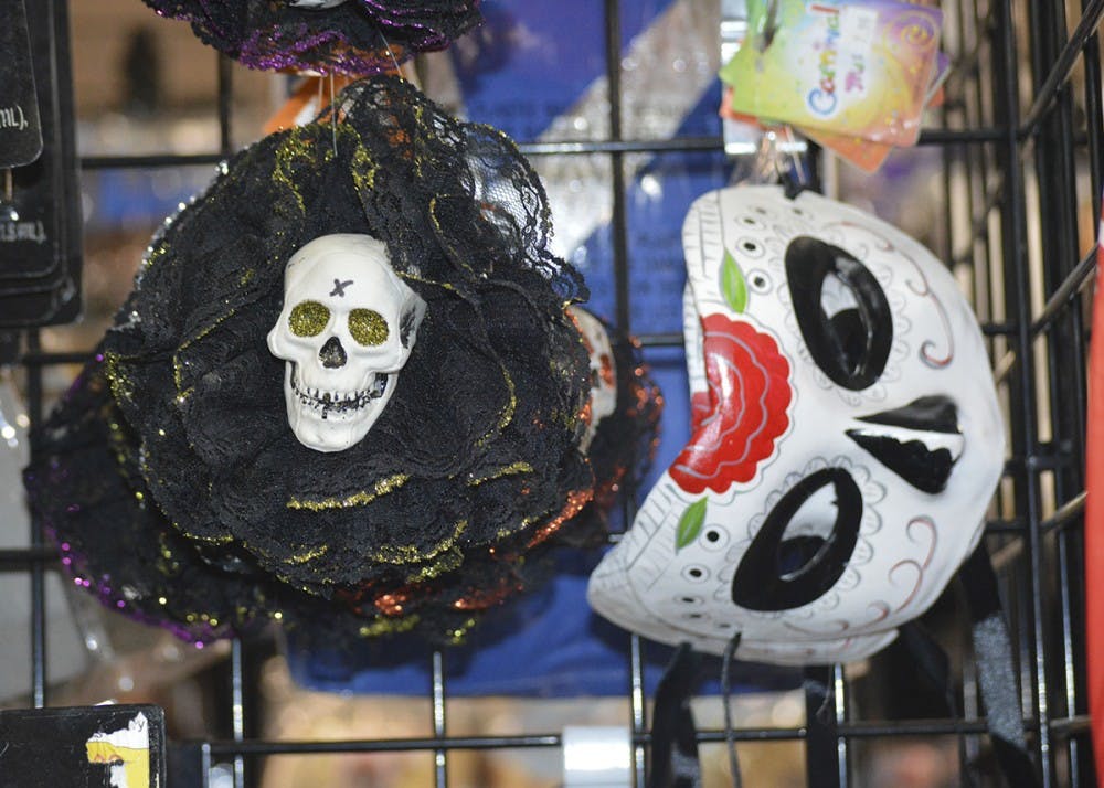 Masks and stickers for Day of the Dead hang alongside Halloween attire. Costumes lined the aisles of Campus Costume preparing for Halloween.
